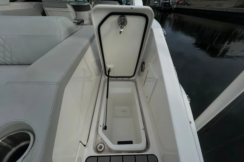 Slide: The Image of 2024 Sea Ray SLX 310 Outboard boat storage compartment open, showcasing interior space. - 17