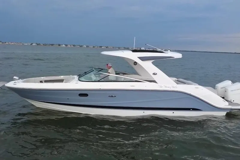 Slide: The Image of 2024 Sea Ray SLX 310 Outboard cruising on calm waters under a clear sky. - 3