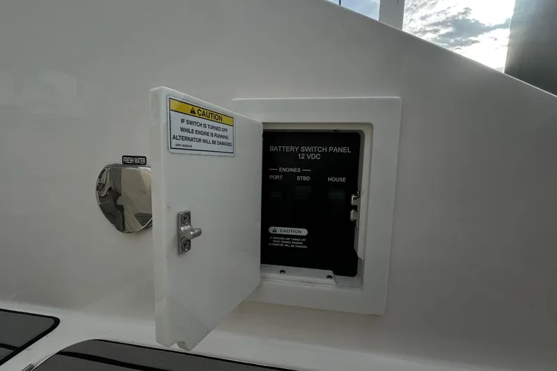 Slide: The Image of Battery switch panel on 2024 Sea Ray SLX 310 Outboard boat, with caution label. - 21