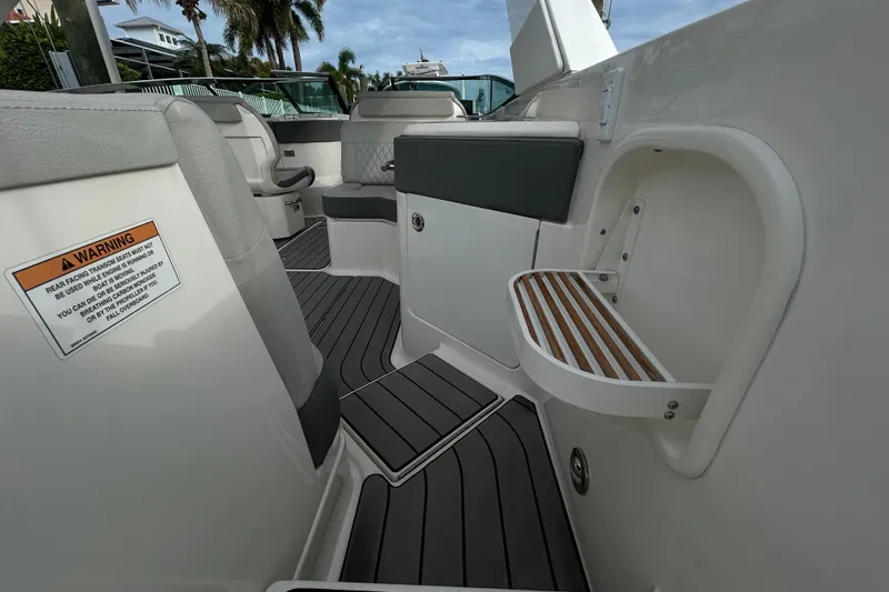 Slide: The Image of 2024 Sea Ray SLX 310 Outboard interior with seating and warning label. - 28