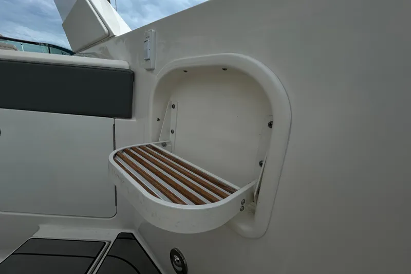 Slide: The Image of 2024 Sea Ray SLX 310 Outboard boat interior detail with wooden shelf. - 29