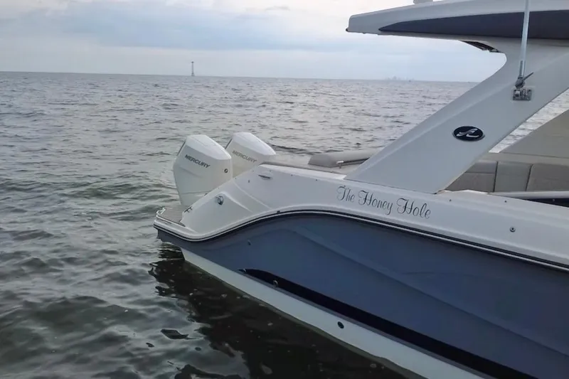 Slide: The Image of 2024 Sea Ray SLX 310 Outboard boat on calm water, featuring dual Mercury engines. - 10