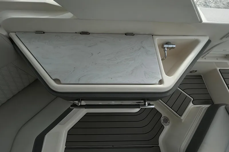 Slide: The Image of 2024 Sea Ray SLX 310 Outboard interior with sink and storage compartment. - 38