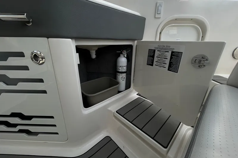Slide: The Image of 2024 Sea Ray SLX 310 Outboard interior storage with fire extinguisher and trash bin. - 45