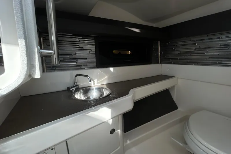 Slide: The Image of 2024 Sea Ray SLX 310 Outboard cabin interior with sink and modern design. - 59