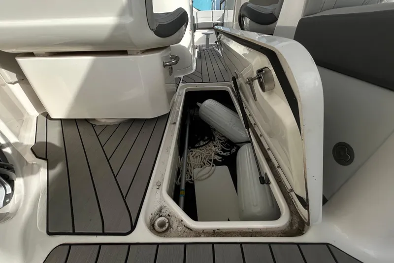 Slide: The Image of 2024 Sea Ray SLX 310 Outboard storage compartment with ropes and fenders on deck. - 61