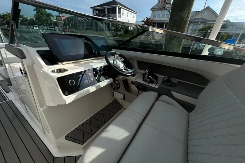 Slide: The Image of 2024 Sea Ray SLX 310 Outboard cockpit with modern controls and luxurious seating. - 63