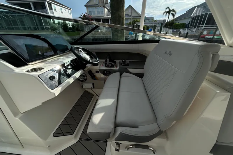 Slide: The Image of 2024 Sea Ray SLX 310 Outboard helm with luxurious seating and modern dashboard. - 64
