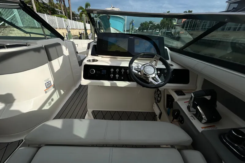 Slide: The Image of 2024 Sea Ray SLX 310 Outboard helm with modern controls and navigation display. - 65