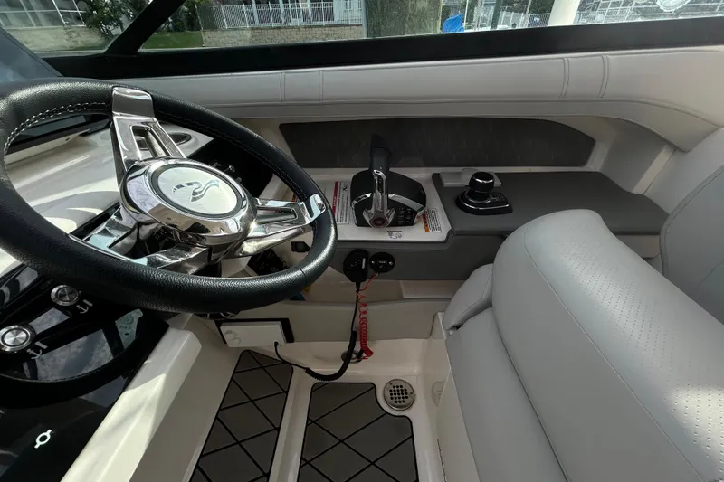 Slide: The Image of 2024 Sea Ray SLX 310 Outboard helm with steering wheel and controls. - 67
