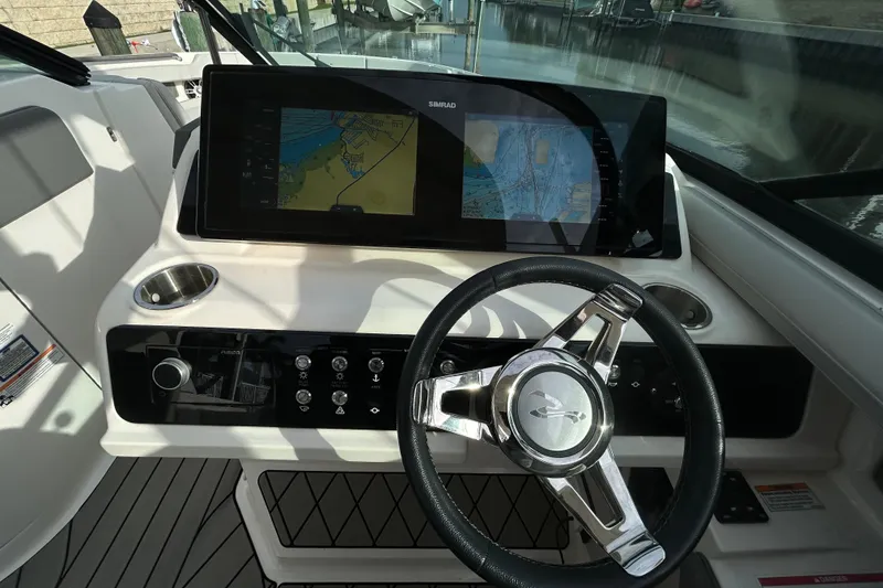 Slide: The Image of 2024 Sea Ray SLX 310 Outboard dashboard with steering wheel and navigation display. - 72