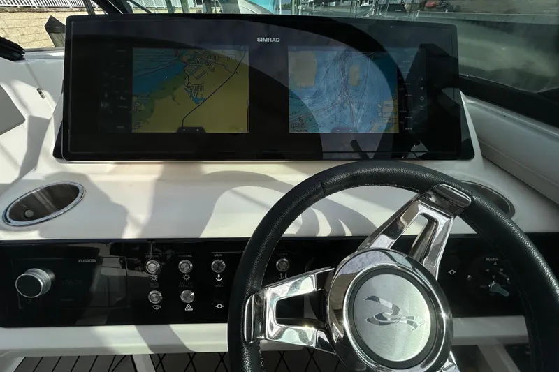 Slide: The Image of 2024 Sea Ray SLX 310 Outboard dashboard with navigation display and steering wheel. - 73