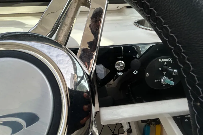 Slide: The Image of 2024 Sea Ray SLX 310 Outboard steering wheel and control panel close-up. - 77
