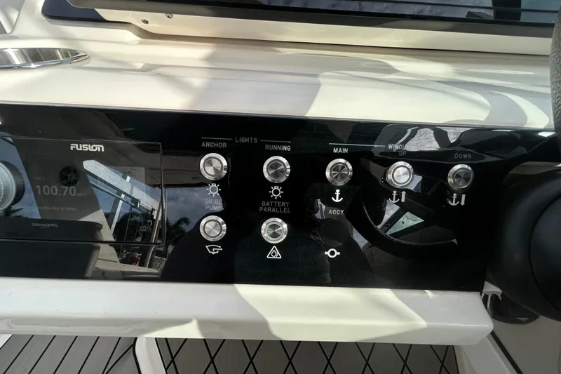 Slide: The Image of Control panel of 2024 Sea Ray SLX 310 Outboard boat with various switches and display. - 78