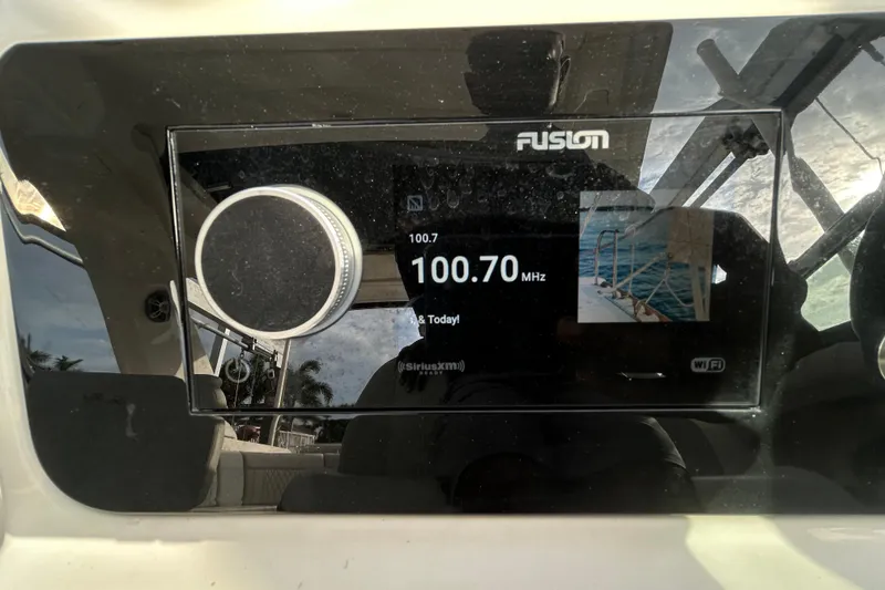 Slide: The Image of 2024 Sea Ray SLX 310 Outboard radio display showing 100.70 MHz frequency. - 79