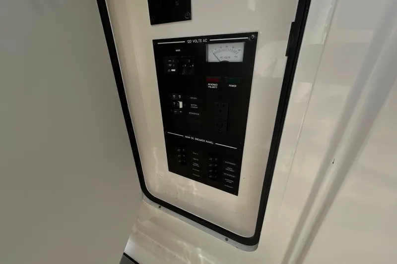 Slide: The Image of Electrical panel on 2024 Sea Ray SLX 310 Outboard boat, featuring voltage and breaker controls. - 85