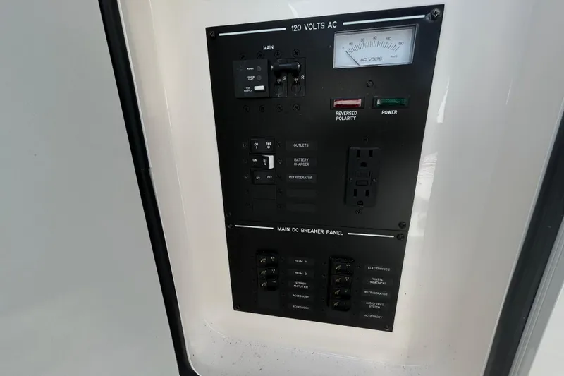 Slide: The Image of Electrical panel on 2024 Sea Ray SLX 310 Outboard, featuring AC and DC breaker controls. - 86