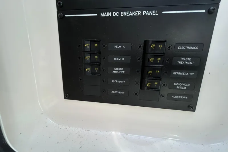 Slide: The Image of Main DC breaker panel on 2024 Sea Ray SLX 310 Outboard boat, featuring labeled switches. - 87