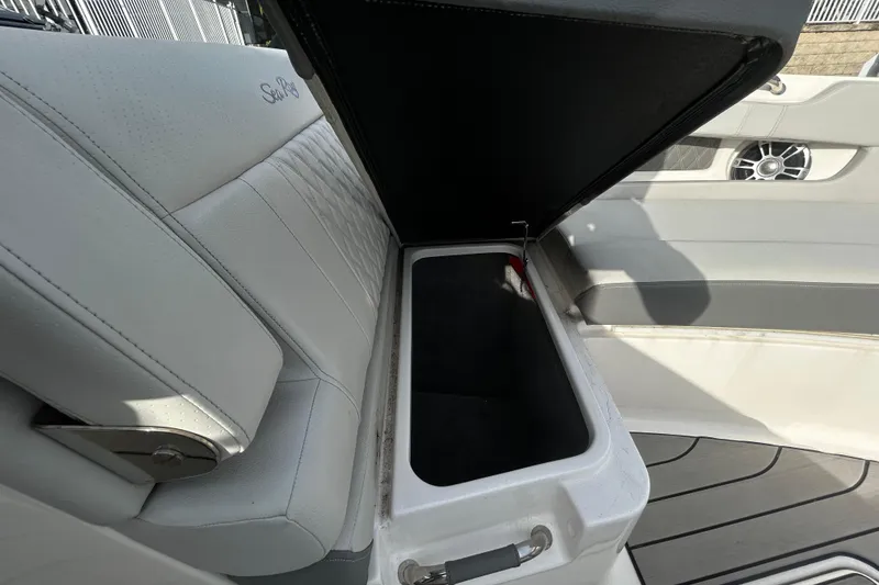 Slide: The Image of 2024 Sea Ray SLX 310 Outboard boat seat with open storage compartment. - 91
