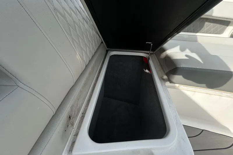 Slide: The Image of 2024 Sea Ray SLX 310 Outboard storage compartment with open lid, showcasing interior space. - 92