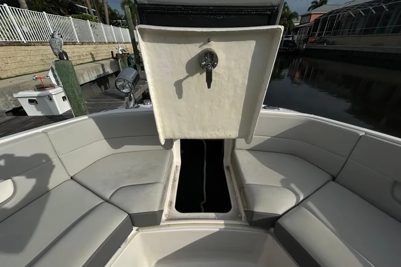 Slide: The Image of 2024 Sea Ray SLX 310 Outboard boat with open storage compartment and cushioned seating. - 95