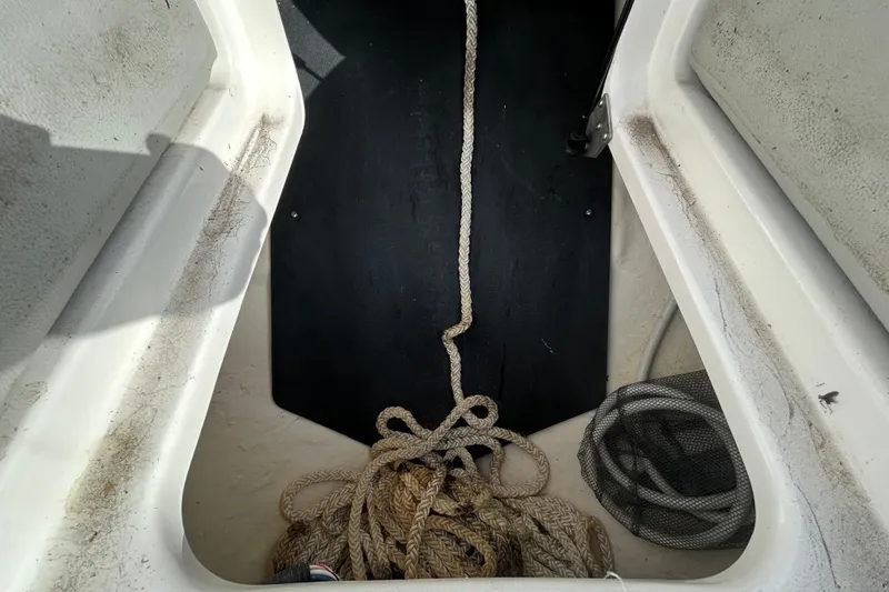 Slide: The Image of Storage compartment of 2024 Sea Ray SLX 310 Outboard with ropes and equipment. - 97