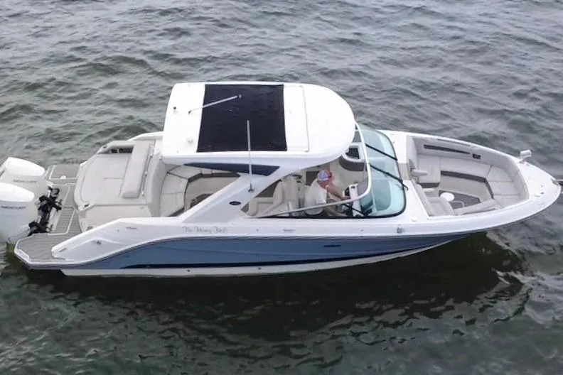 Slide: The Image of 2024 Sea Ray SLX 310 Outboard cruising on water, showcasing sleek design and spacious seating. - 7