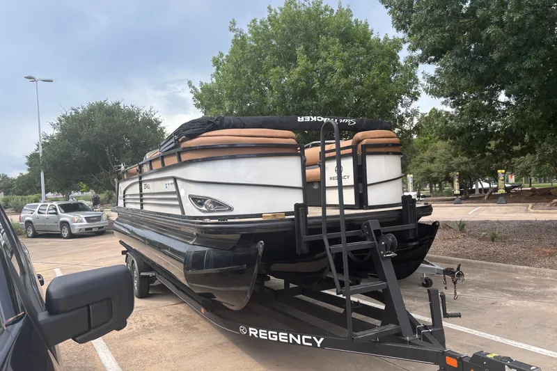Slide: The Image of 2018 Regency 254 LE3 Sport pontoon boat on trailer in parking lot. - 1