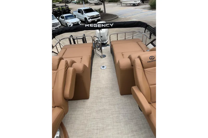 Slide: The Image of 2018 Regency 254 LE3 Sport boat interior with tan seating and outdoor view. - 3