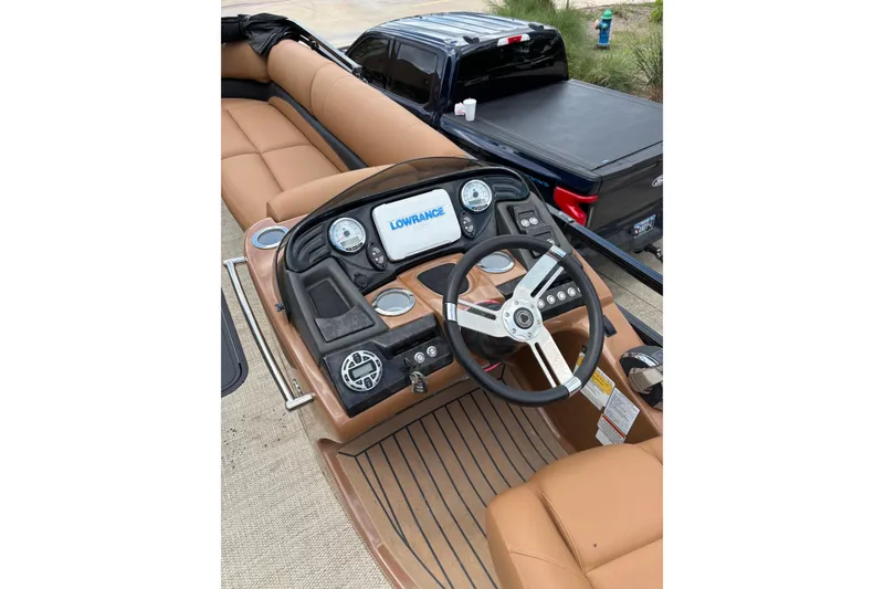 Slide: The Image of 2018 Regency 254 LE3 Sport boat dashboard with Lowrance display and tan seating. - 4
