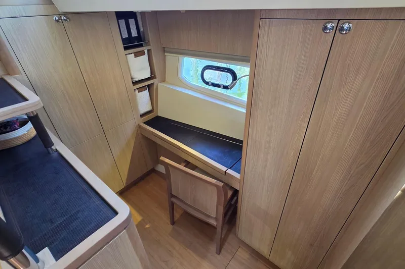 Slide: The Image of Interior of 2020 Aquila 44 Yacht with wooden cabinetry and a small desk area. - 25
