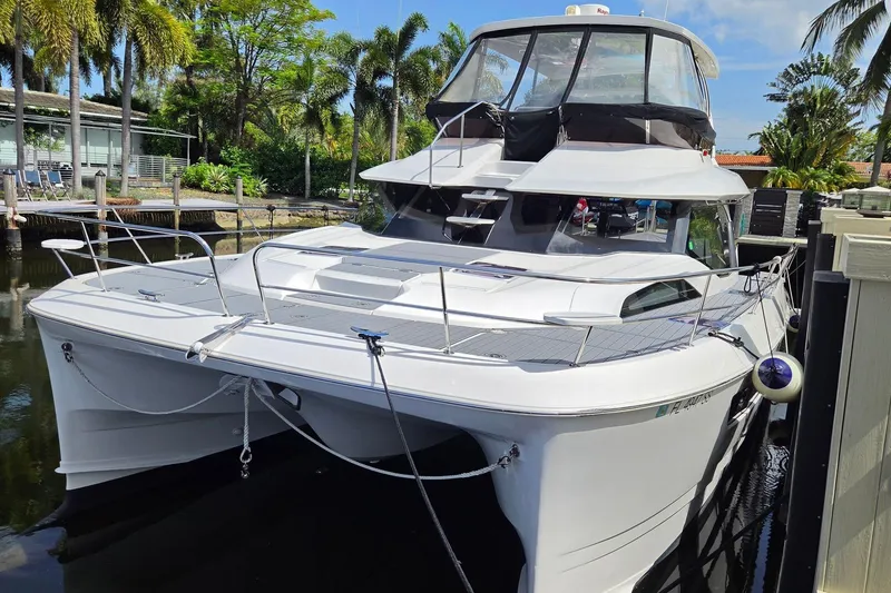 Slide: The Image of Aquila 44 Yacht 2020 docked, surrounded by lush palm trees and calm waters. - 3