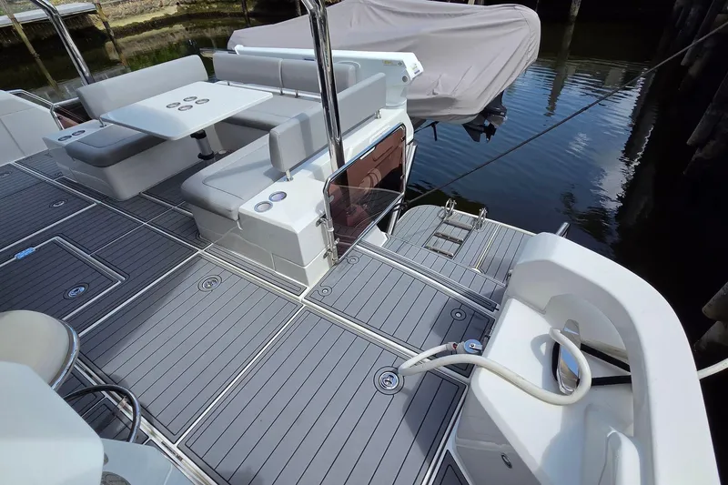 Slide: The Image of 2020 Aquila 44 Yacht deck with seating and table, docked by the water. - 32