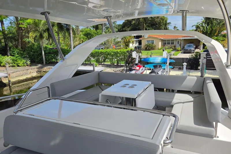 Slide: The Image of Luxurious seating area on a 2020 Aquila 44 Yacht, docked near a waterfront home. - 34