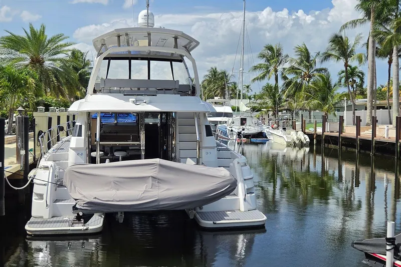 Slide: The Image of Aquila 44 Yacht 2020 docked in a tropical marina with palm trees. - 4