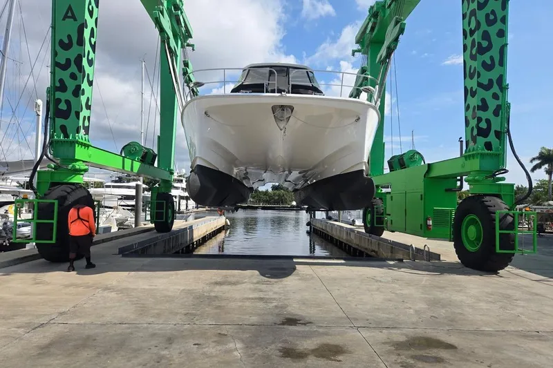 Slide: The Image of Aquila 44 Yacht 2020 being lifted by green crane at marina. - 40
