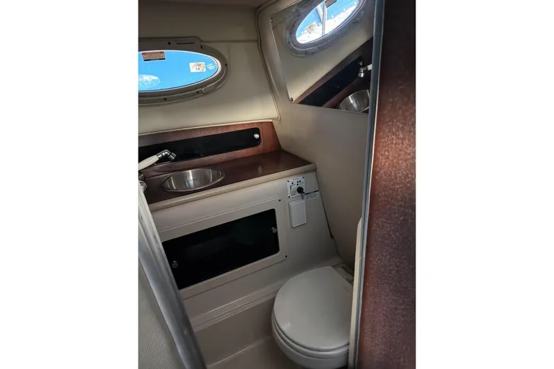 Slide: The Image of 2014 Robalo R265 Walkaround cabin interior with sink and toilet. - 12