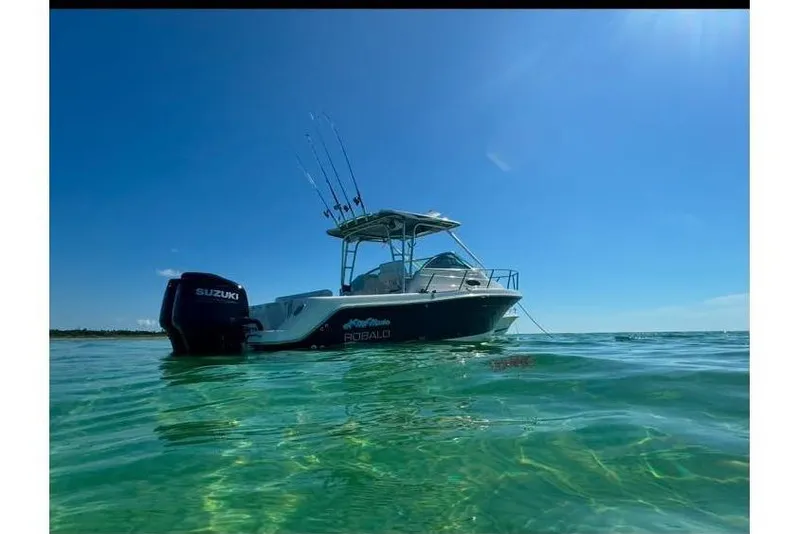 Slide: The Image of 2014 Robalo R265 Walkaround boat on clear water under blue sky. - 2