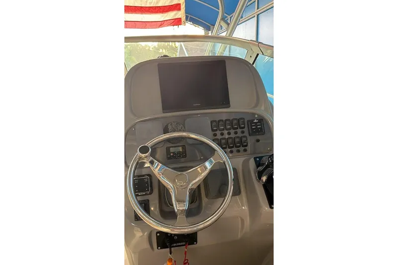 Slide: The Image of 2014 Robalo R265 Walkaround helm with steering wheel and control panel. - 7