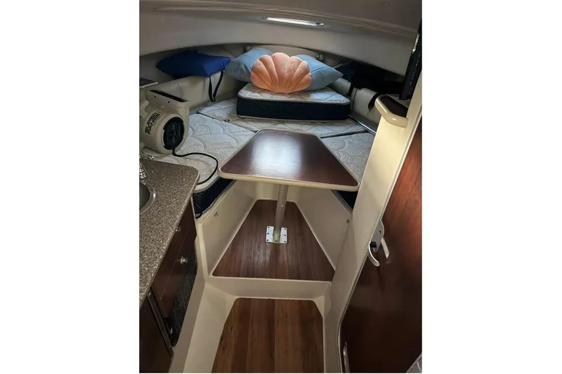 Slide: The Image of 2014 Robalo R265 Walkaround cabin interior with table and seating area. - 9