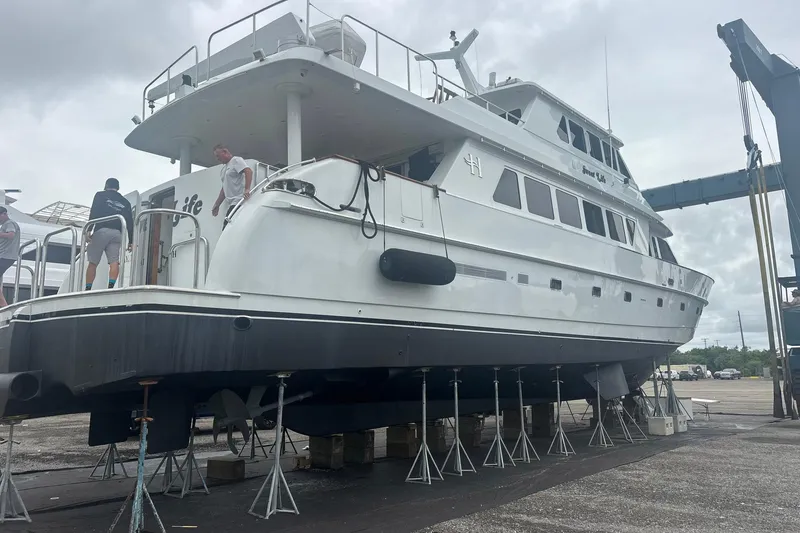 Slide: The Image of 2001 Hargrave 94 yacht on dry dock for maintenance, with crew working on deck. - 113