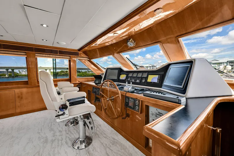Slide: The Image of Luxurious helm of 2001 Hargrave 94 yacht with modern navigation equipment and plush seating. - 29