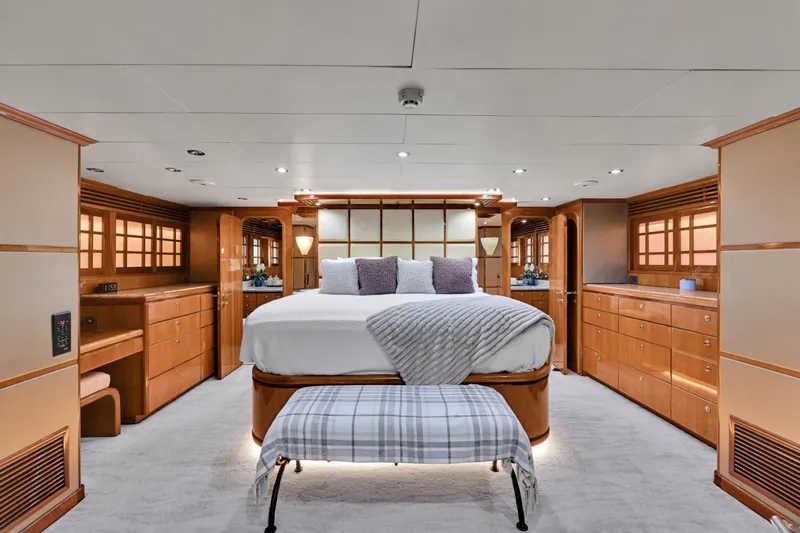 Slide: The Image of Luxurious master bedroom on 2001 Hargrave 94 yacht, featuring elegant wood cabinetry and plush bedding. - 46