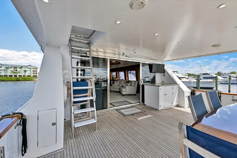 Slide: The Image of Luxurious 2001 Hargrave 94 yacht deck with seating, ladder, and marina view. - 82