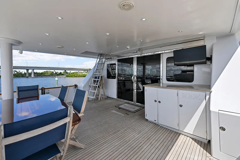 Slide: The Image of Luxurious 2001 Hargrave 94 yacht deck with dining area, TV, and waterfront view. - 83