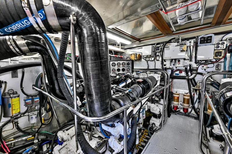 Slide: The Image of Engine room of a 2001 Hargrave 94 yacht, showcasing complex machinery and piping. - 94
