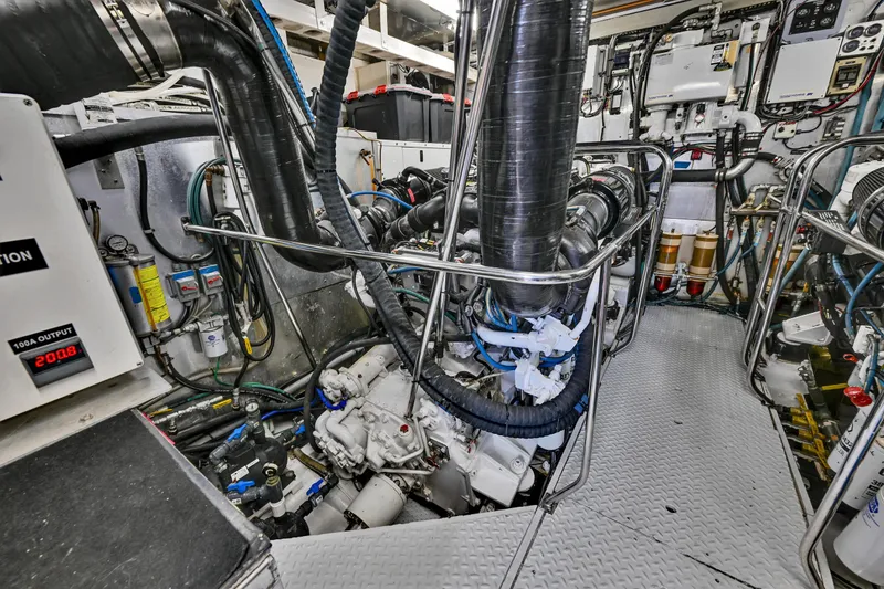 Slide: The Image of Engine room of a 2001 Hargrave 94 yacht, showcasing complex machinery and piping. - 97