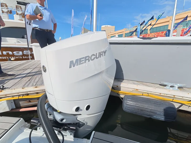 Slide: The Image of A Mercury outboard motor at a boat dock, with people in the background. - 2