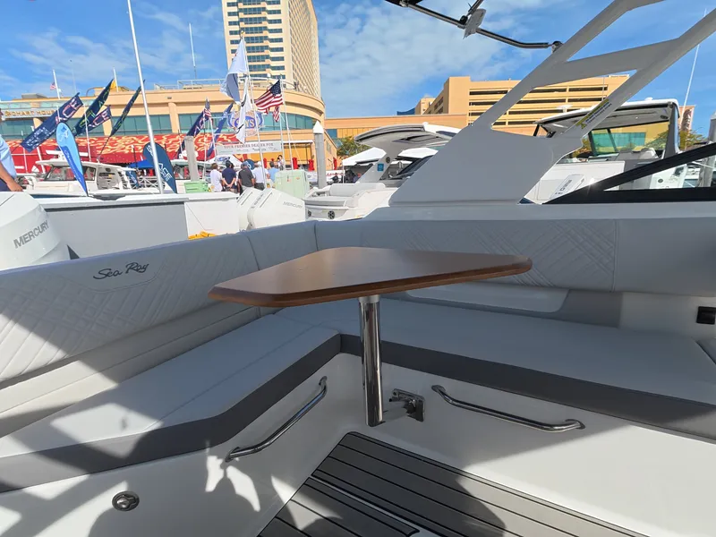 Slide: The Image of The image shows the cockpit of a Sea Ray SDX 270 Outboard with a wooden table and white seating. - 10