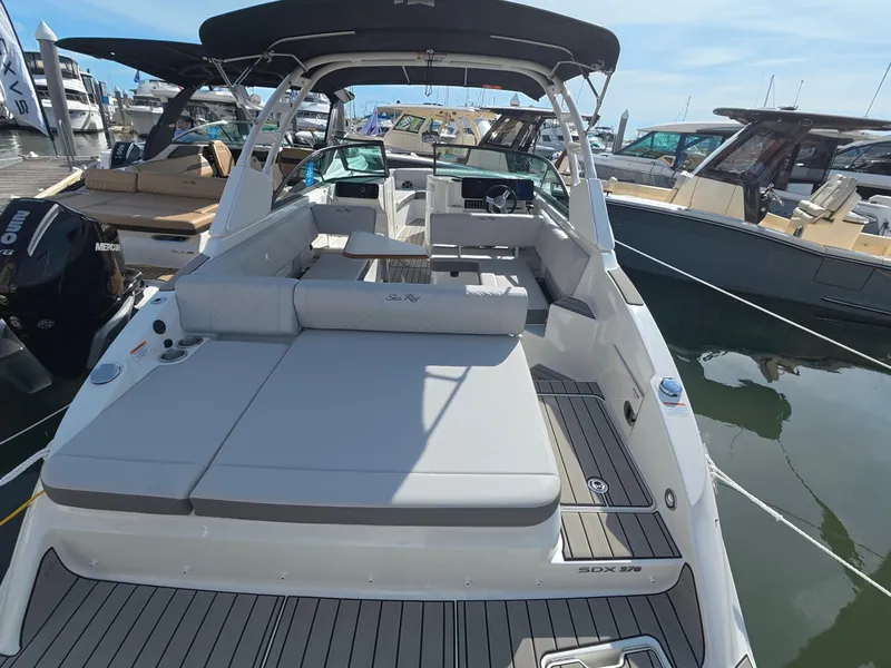 Slide: The Image of The image shows a Sea Ray SDX 270 Outboard boat at a marina, featuring a spacious deck and seating area. - 4